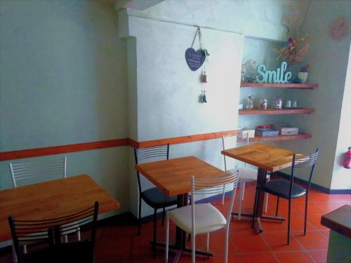 two tables and chairs in a restaurant with a smile sign on the wall at Folia in Rome