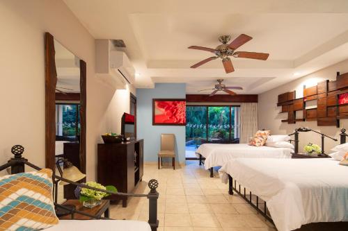 a bedroom with two beds and a ceiling fan at Pumilio Mountain & Ocean Hotel in Jacó
