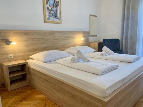 1 dormitorio con 2 camas con sábanas blancas en Rooms & Pansion Odmor, en Rovanjska