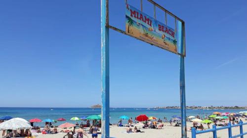 a sign on a beach with a crowd of people at Casa Vacanza La Isla Bonita in Isola delle Femmine