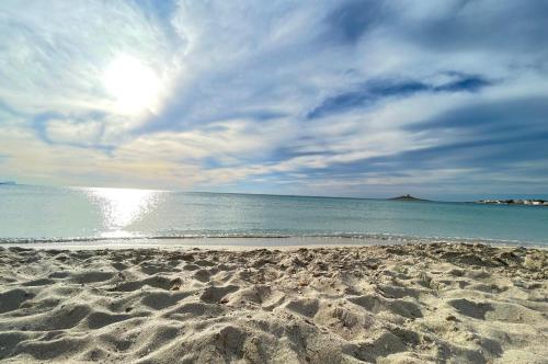a sandy beach with the ocean on a cloudy day at Casa Vacanza La Isla Bonita in Isola delle Femmine
