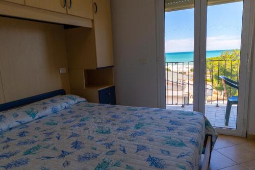 a bedroom with a bed and a view of the ocean at Residence Palazzo Sayonara in Tortoreto Lido