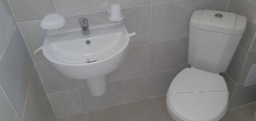 a bathroom with a white toilet and a sink at Ema in Vama Veche