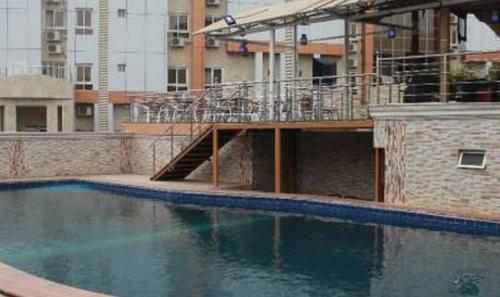 ein leeres Schwimmbad in einer Stadt mit einem Gebäude in der Unterkunft Room in Lodge - Grand Cubana Hotels-alcove Room in Jabi