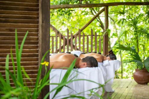 a group of men in white towels laying on a porch at Pumilio Mountain & Ocean Hotel in Jacó
