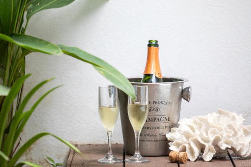 a bottle of champagne and two glasses on a table at Pumilio Mountain & Ocean Hotel in Jacó