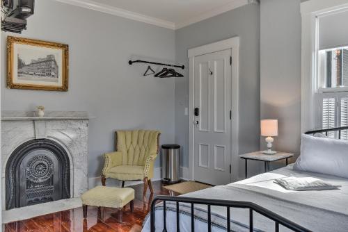 1 dormitorio con 1 cama y chimenea en The Burrell House, en Keene