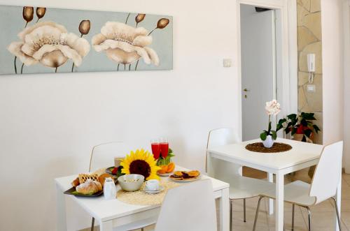 a white dining room with a table and a table and chairs at RE UMBERTO b&b - Suite di charme e Country rooms in San Salvo