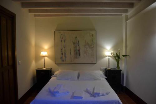 a bedroom with a white bed with two lamps at La Posada de Norberta in Gata