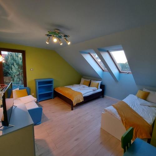 a attic bedroom with two beds and a tv at Slow life nad jeziorem in Łukta