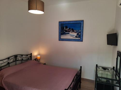 1 dormitorio con 1 cama y una foto en la pared en Les Jardins De Santa Giulia - Charmante chambre d'hôte, en Porto Vecchio