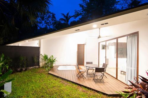 a house with a wooden deck with a table and chairs at Pumilio Mountain & Ocean Hotel in Jacó