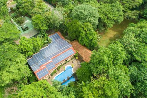 an overhead view of a house with a pool in the forest at Pumilio Mountain & Ocean Hotel in Jacó