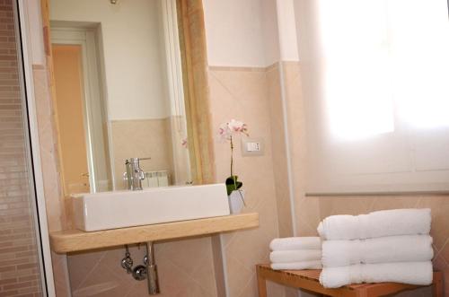 a bathroom with a sink and a mirror and towels at RE UMBERTO b&b - Suite di charme e Country rooms in San Salvo