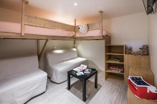 レ・デュー・アルプにあるAppartement Edelweiss SKIOPIEDS - Centre Stationの小さな客室で、二段ベッド2台、テーブルが備わります。