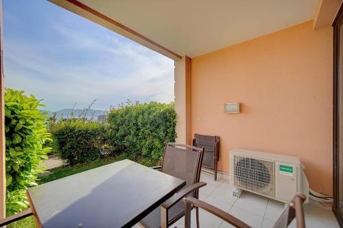 een balkon met een tafel en stoelen en een ventilator bij IMMOGROOM - 2 Rooms - Renovated - Pool - Air conditioning - Parking - in Cannes