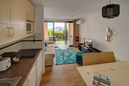 een keuken en een woonkamer met een tafel en stoelen bij IMMOGROOM - 2 Rooms - Renovated - Pool - Air conditioning - Parking - in Cannes