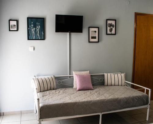 a room with a couch with a tv on the wall at Kiki's Apartments in Néos Pírgos