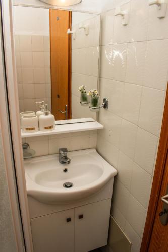 a bathroom with a sink and a mirror at Kiki's Apartments in Néos Pírgos