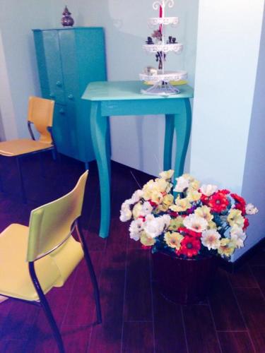 a table with a blue table with a bouquet of flowers at Magnolia House in Taurianova