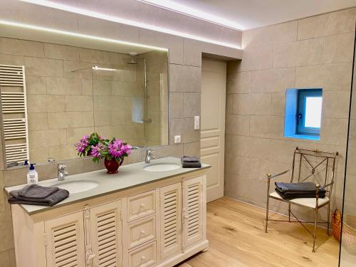 bagno con lavandino, specchio e sedia di Maison du Cocher a Cluny