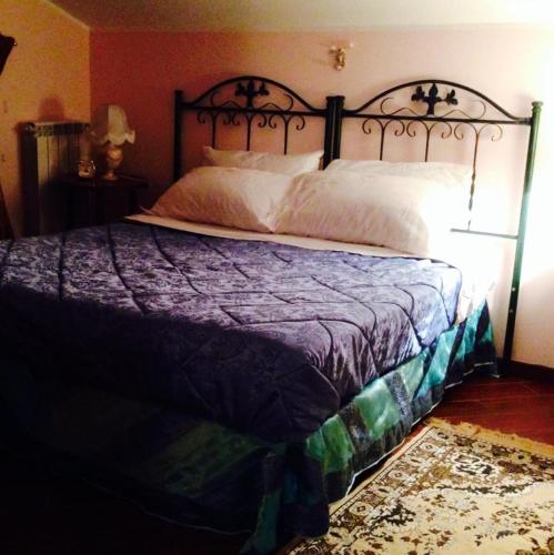 a bedroom with a bed with a purple comforter at Magnolia House in Taurianova