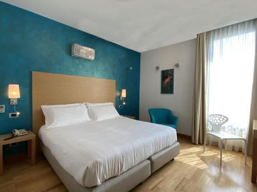 a bedroom with a large bed and a blue wall at Atlantic Park Hotel in Fiuggi