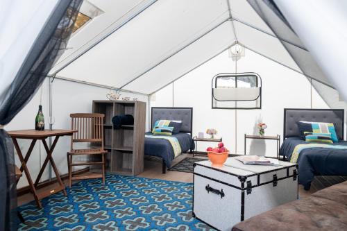 a room with two beds and a table in a tent at Surrey Resort and Gym in Guerneville