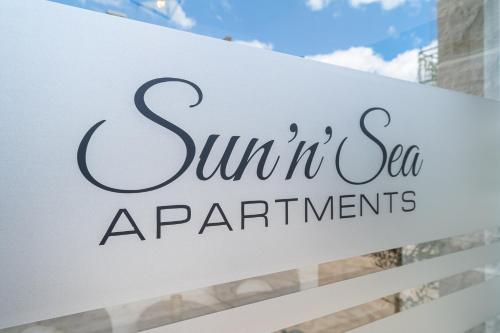 um sinal para apartamentos no mar iluminados em frente a um edifício em Sun and Sea Apartments em Budva