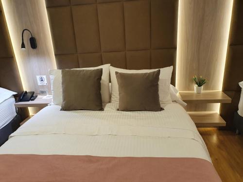 a bedroom with a large white bed with two pillows at HOTEL SANTORI in Pasto