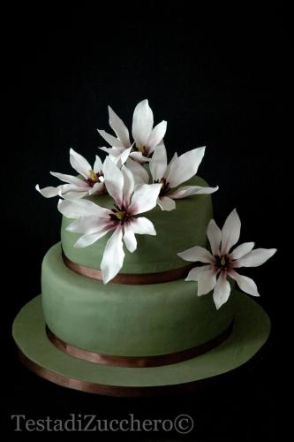 a green cake with white flowers on top of it at Magnolia House in Taurianova
