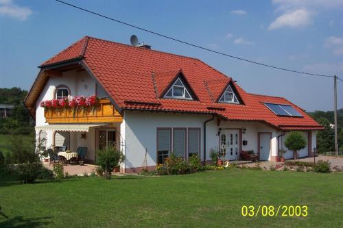 a white house with an orange roof at Urlaub auf dem Bauernhof Marx in Kelberg