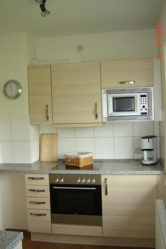 a kitchen with a stove and a microwave at Urlaub auf dem Bauernhof Marx in Kelberg