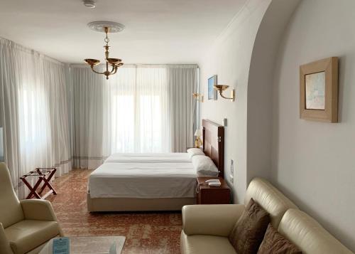 a hotel room with a bed and a couch at Hotel Paraíso Del Mar in Nerja