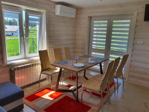 a dining room with a table and chairs and windows at Zielone Zagrody - Stafieje in Grodzisko Dolne