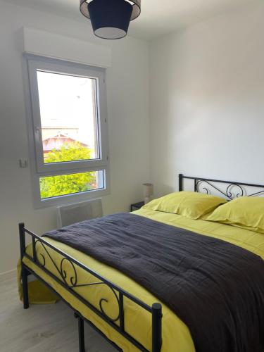 - une chambre avec un lit doté de draps jaunes et une fenêtre dans l'établissement Arcachon Situation exceptionnelle proche plage, à Arcachon
