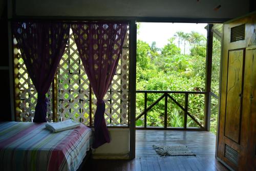 a bedroom with a bed and a door to a balcony at Cabinas carol in Pavones
