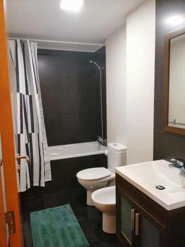 een badkamer met een wit toilet en een wastafel bij The Blue Angel in Viana do Castelo