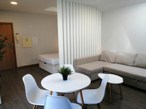 a living room with a couch and a table and chairs at The Blue Angel in Viana do Castelo