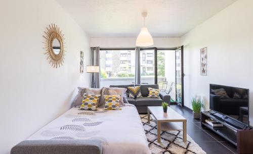 un salon avec un grand lit et un canapé dans l'établissement Aux portes de Bordeaux Le Compostelle MindUrGuest, à Pessac