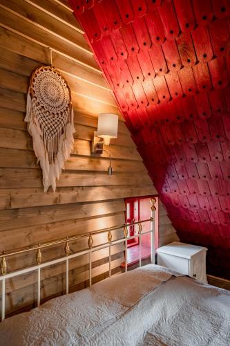 a bedroom with wooden walls and a bed with red lights at Soomaa Puhkeküla in Riisa