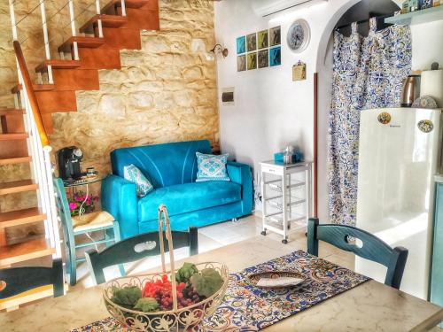 salon z niebieską kanapą i stołem w obiekcie Lilibeth Houses - Charming & Lovely views w mieście Scicli