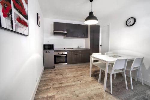 une cuisine et une salle à manger avec une table et des chaises blanches dans l'établissement Grande maison centre ville THOUARS, à Thouars