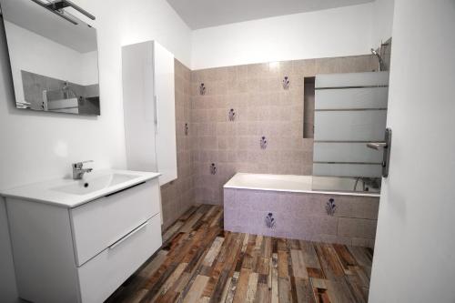une salle de bain avec un lavabo, une baignoire et un miroir dans l'établissement Grande maison centre ville THOUARS, à Thouars