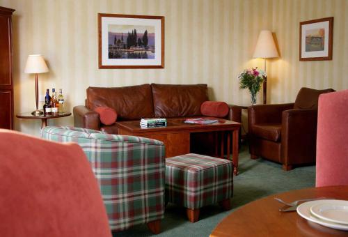 a living room with a couch and a table and chairs at Macdonald Spey Valley Resort in Aviemore