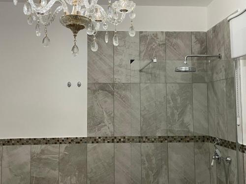 a bathroom with a shower with a chandelier at luxury villa Arianna in Tarano