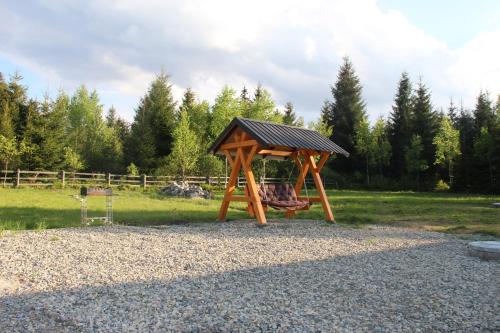 a wooden swing set with a roof in a park at Шале Вілія in Vorokhta