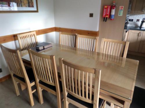 a dining room table and chairs with a wooden table and a table and chairsktop at Macdonald Spey Valley Resort in Aviemore