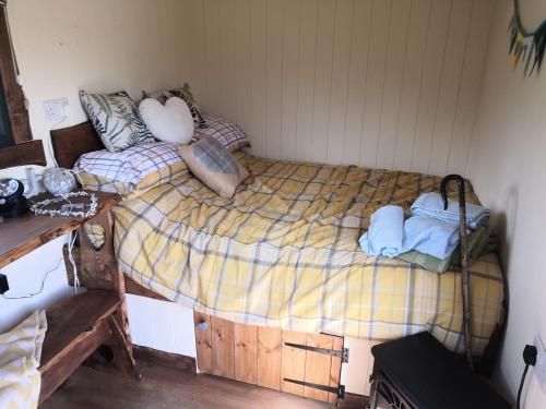 Y Cwtch في Trefeglwys: غرفة نوم بسرير وبطانيتين ومخدات