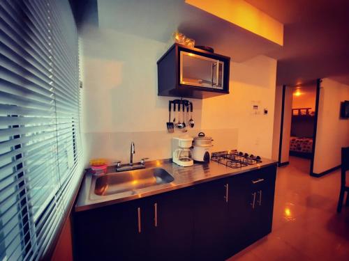 a kitchen with a sink and a counter top at Apartamento privado a 2 kilometros del Parque del Café in Montenegro